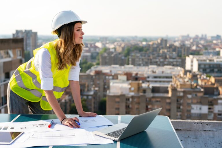 Portrait of engineer businesswoman at construction site. Female architect with blueprint.