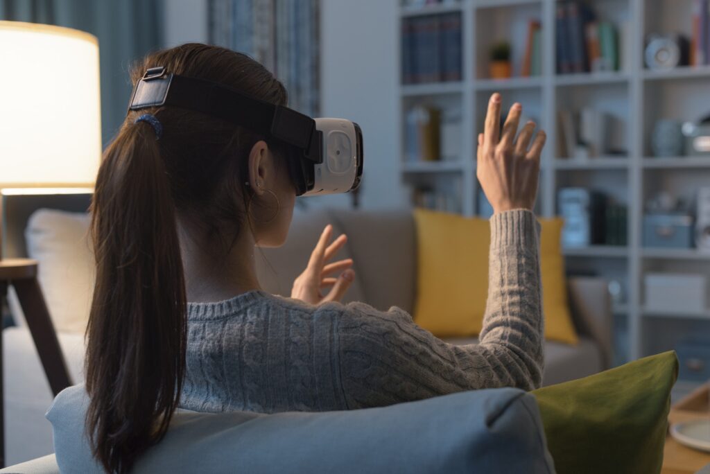 Woman relaxing on the sofa and interacting with virtual reality