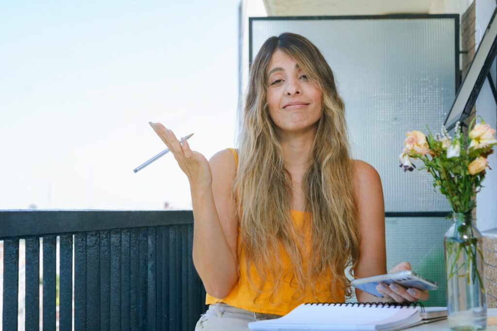 young woman on the balcony looking at the camera making resignation gesture with her hands and face