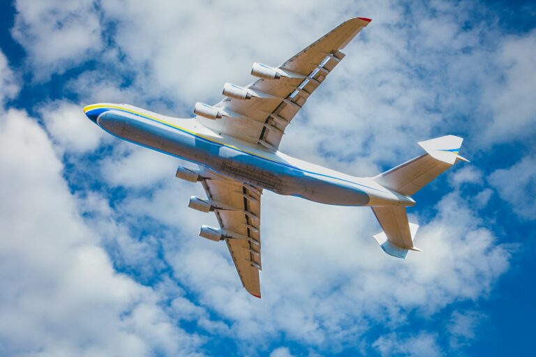 A large cargo plane flies in the blue sky. Aviation air transport. Airplane symbol.