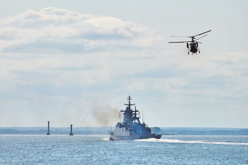 Battleship war ship corvette during naval exercises and helicopter maneuvering over sea, warships