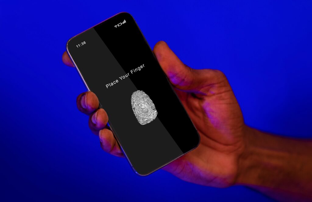 Black man holding phone with fingerprint scanning app