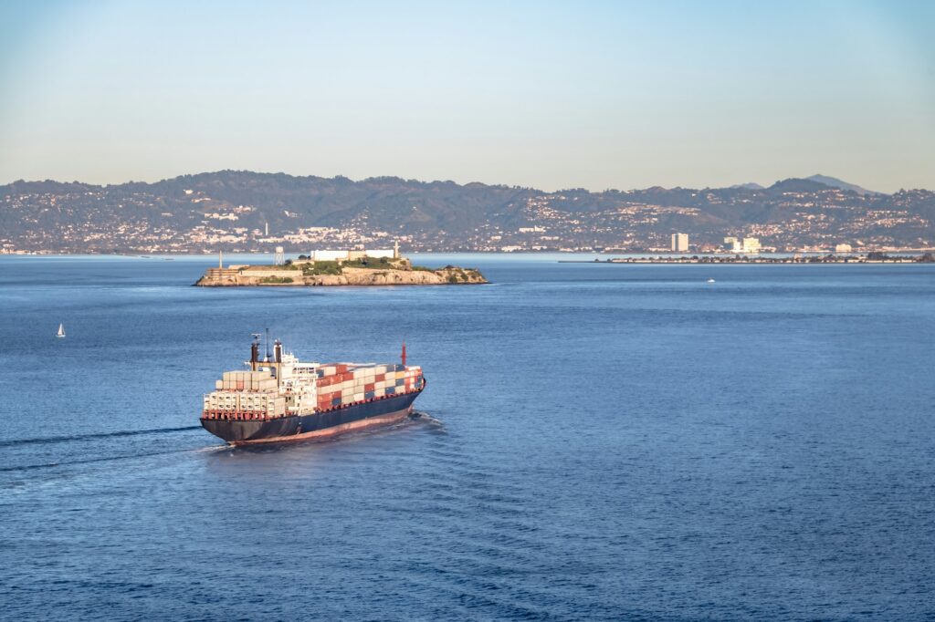 Container Cargo Ship entering San Francisco Bay and Alcatraz Island - San Francisco, California, USA