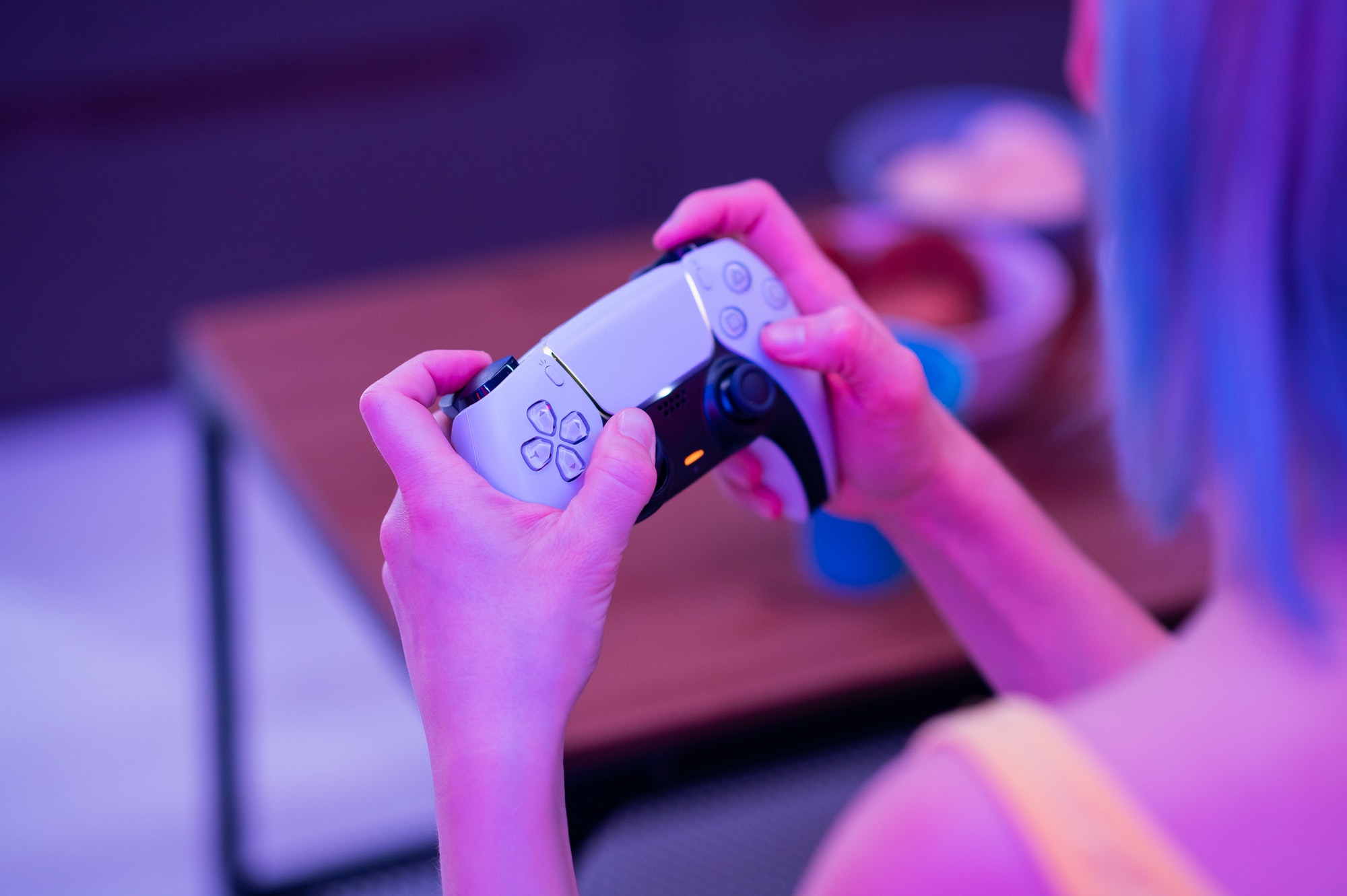 Girl with next gen controller in her hands playing games at home