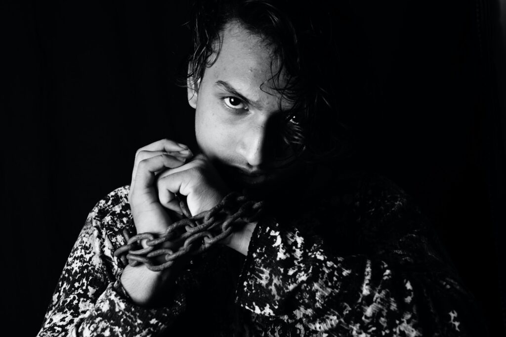 Portrait of a young asian man with a metal chain around his hands