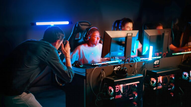 Professional photographer filming teens playing in video game club