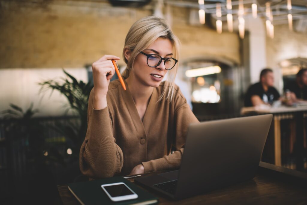 skilled female copywriter doing distance freelance job while browsing information on netbook