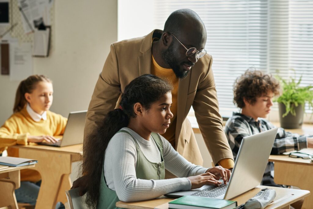 Teacher teaching basics of using computer