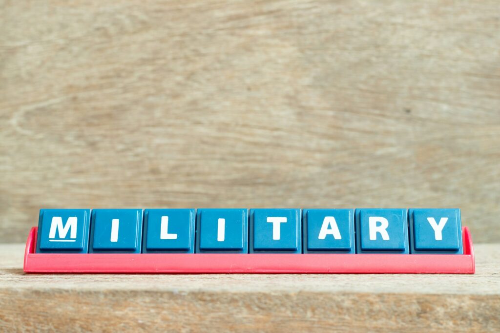 Tile alphabet letter with word military in red color rack on wood background