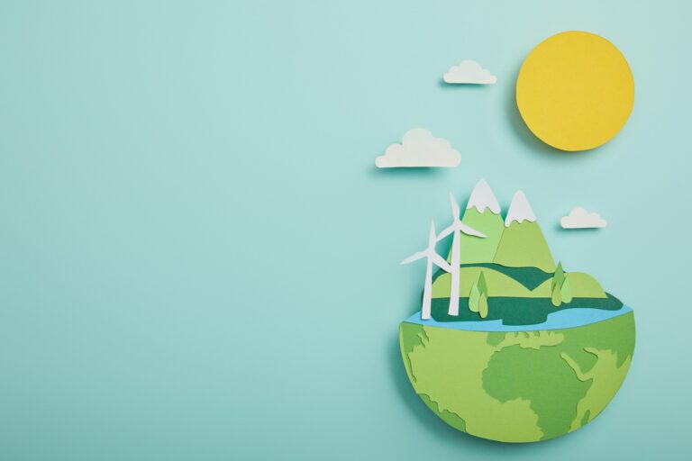 top view of paper cut planet with renewable energy sources on turquoise background, earth day