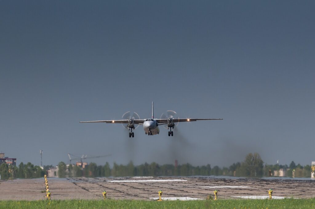 turboprop old aircraft taking off with smoke, fly low over the military runway.