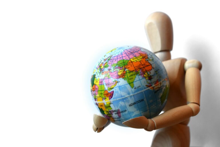 Wooden human figure holding globe planet Earth, world economic crisis