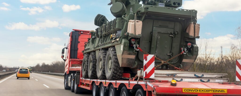 Back view armoured personnel carrier stryker with air defense system trailer hauler carrier truck