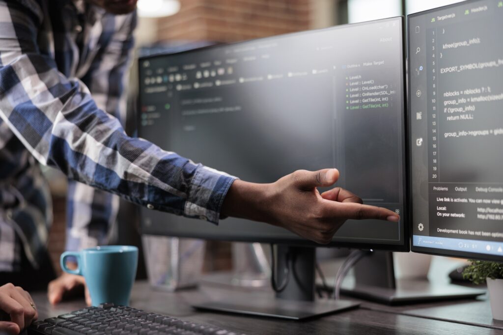 Blockchain engineer pointing out mistake in network security software line code.