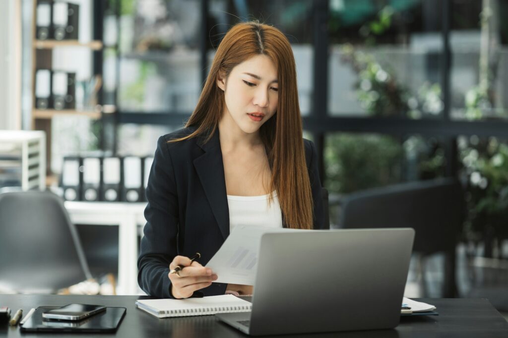 Business woman working at office with laptop and documents on his desk