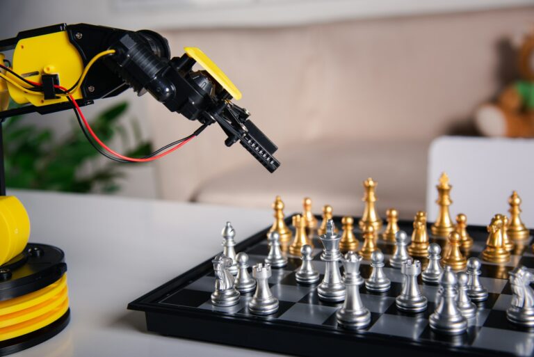 Closeup yellow robot arm playing move chess on chessboard