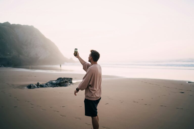 hipster guy generation z influencer shooting video about summer recreation on coast