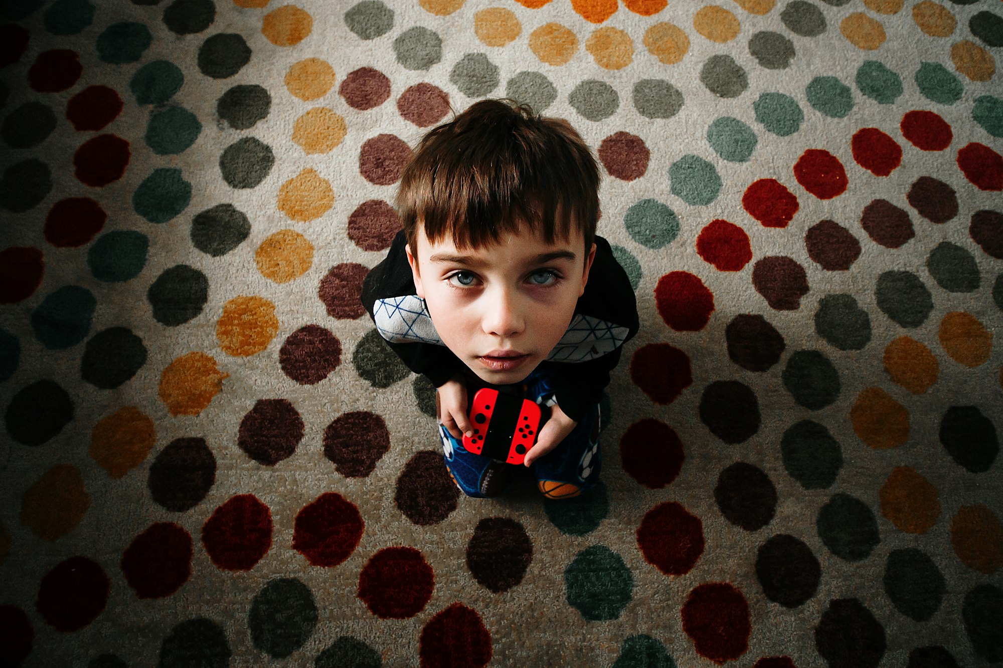 Little Boy playing the Nintendo Switch, wide angle lens point of view from above