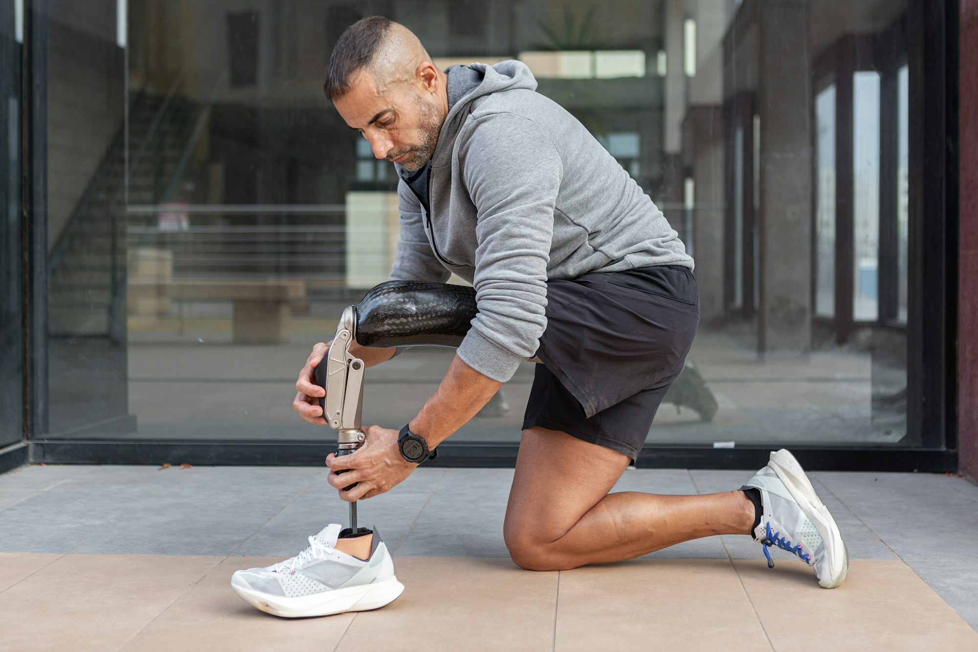 Male athlete adjusting prosthetic leg