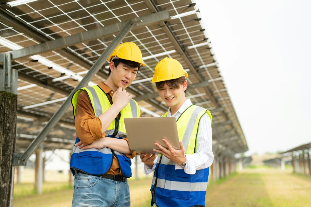 Male engineer with laptop working on solar panels