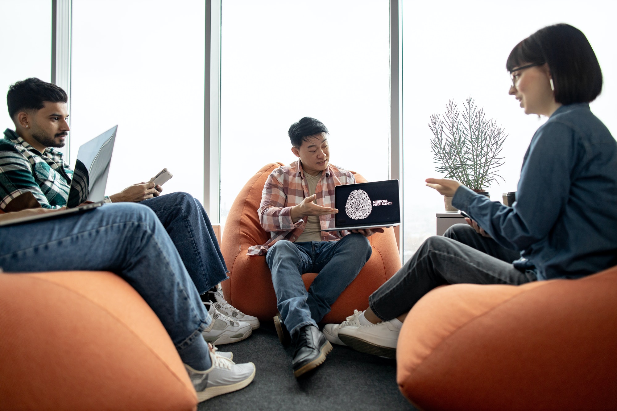 Man pointing at AI image while mates chatting at workplace