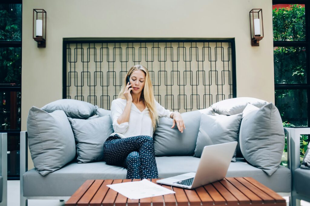 proud caucasian woman ceo using technology on terrace working remotely making mobile call