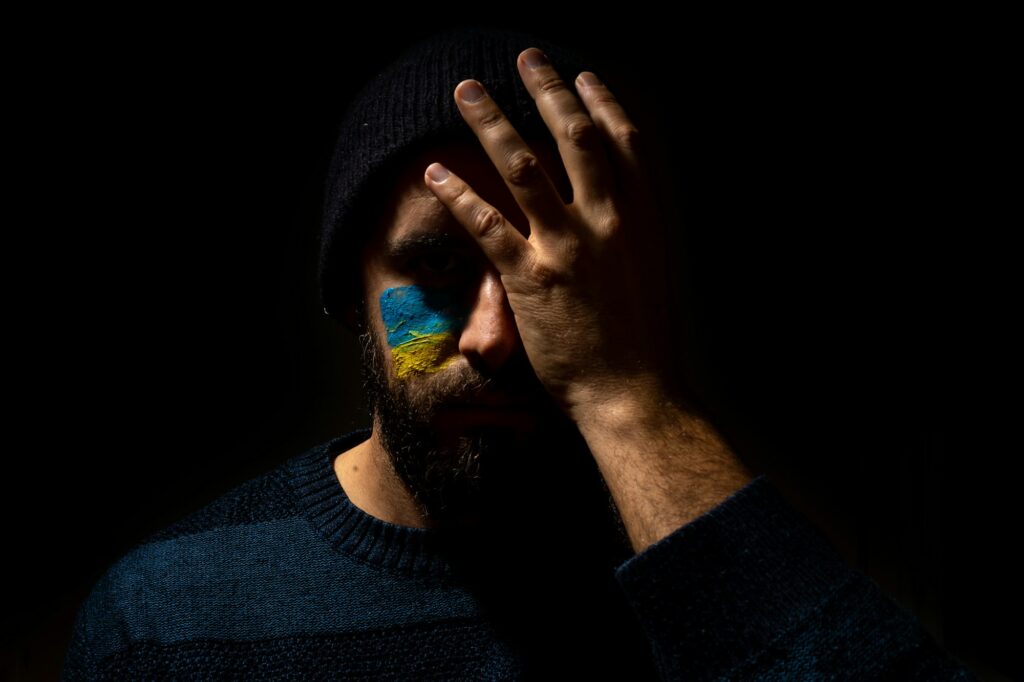 Stop war, conflict between Ukraine and Russia. A young Ukrainian with his face painted