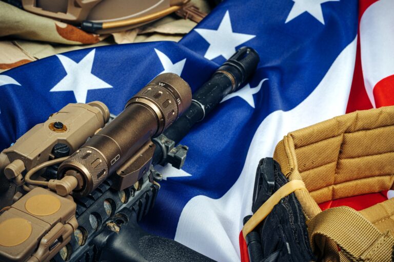 U.S. battle flag and assault rifle on the wooden table