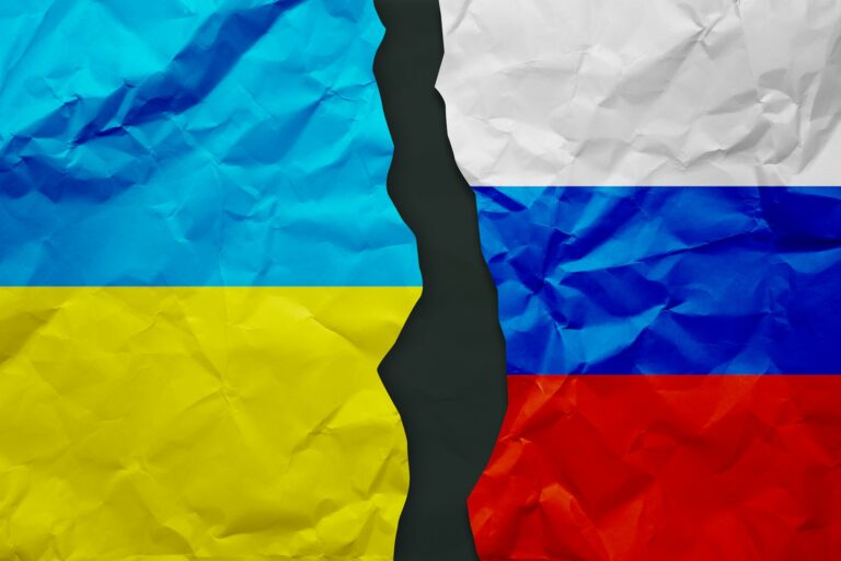 Ukraine and Russia flags painted on paper wall background, political partnership conflicts concept