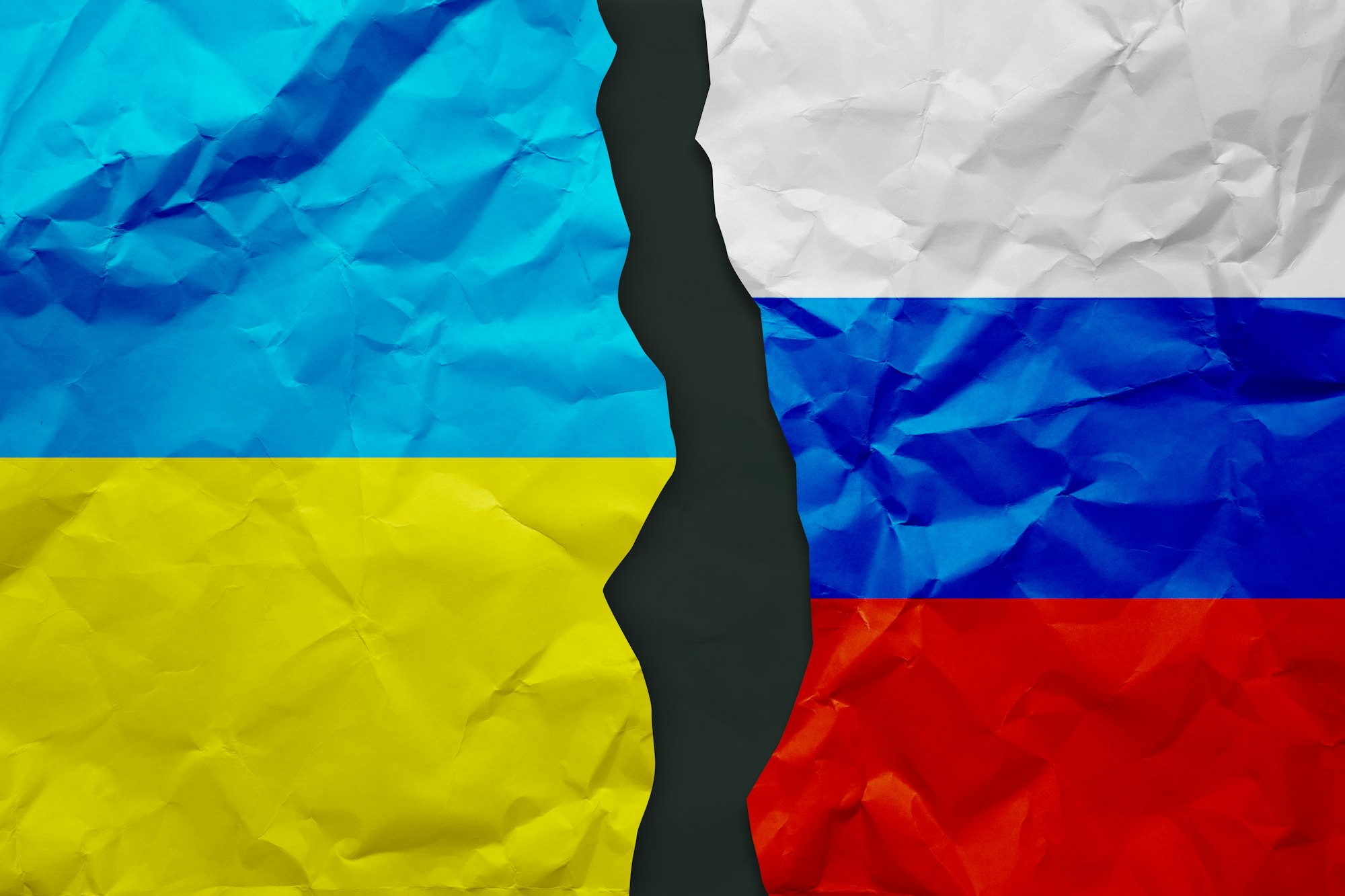 Ukraine and Russia flags painted on paper wall background, political partnership conflicts concept