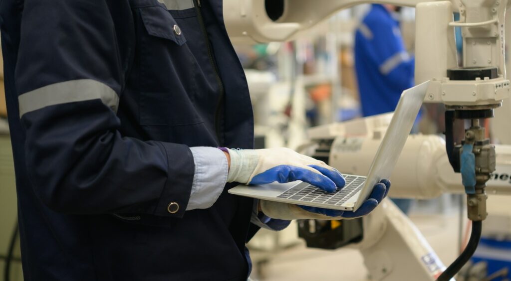 Young male engineers are manipulating a welding robot hand.