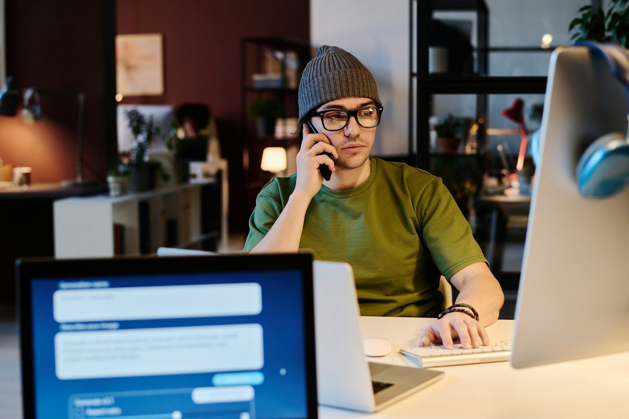 Young serious male AI designer at work