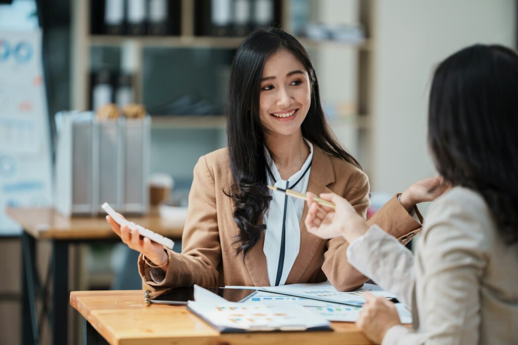 Young smiling businesswomen having a discussion with CEO in the office.