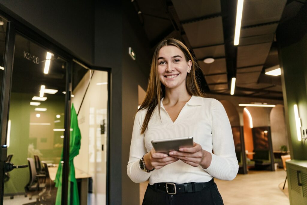 A young woman smiling emotion marketing specialist uses a new tablet and chat bot. The manager