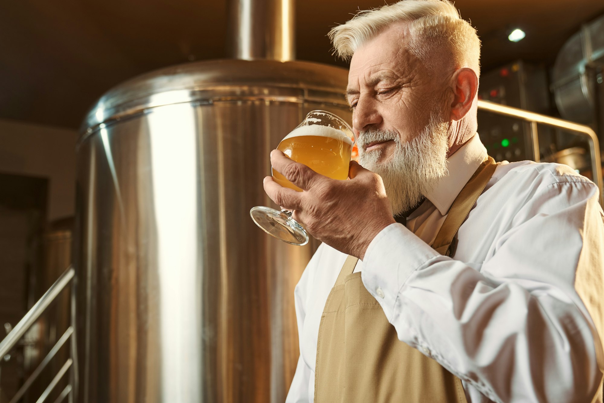 Brewery expert tasting cold large beer with foam