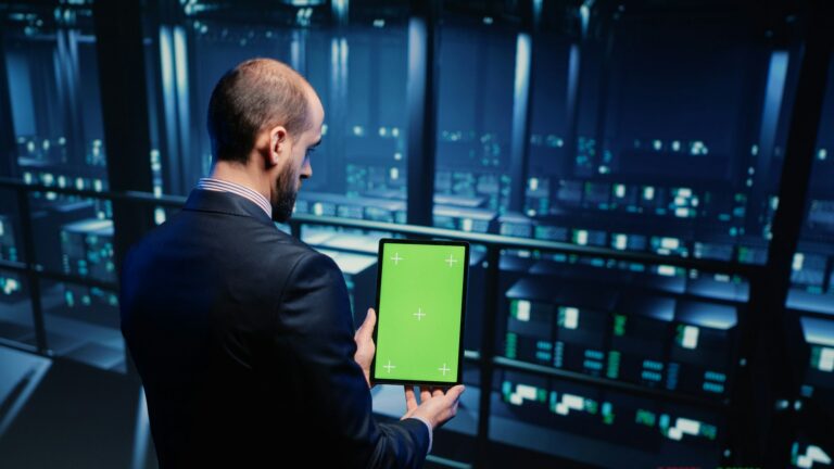 Data center technician holding tablet with green screen