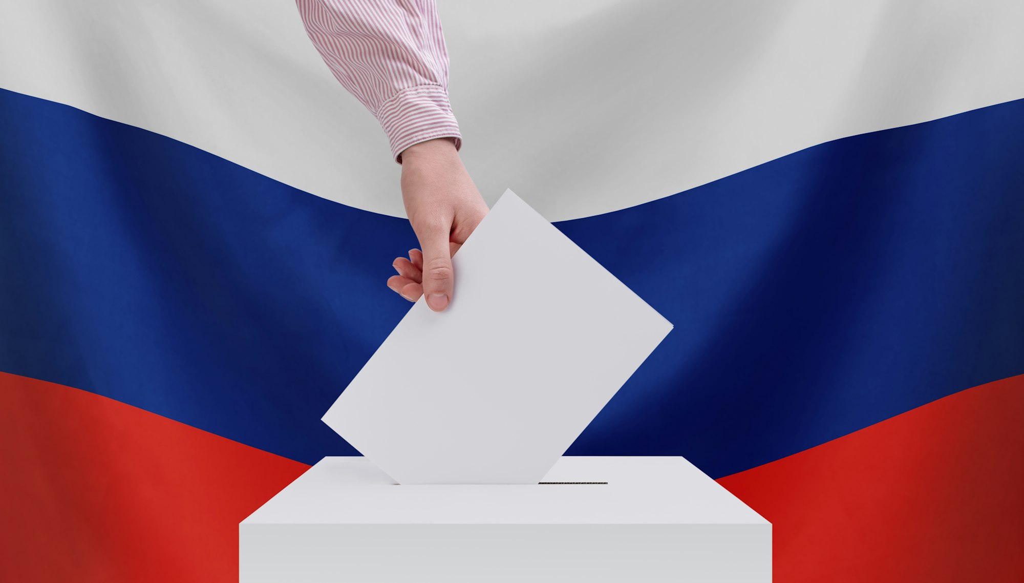 Elections, Russia. The concept of elections. A hand throws a ballot into the ballot box.Russian flag