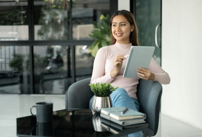 Female CEO in casual wear smiling and using tablet working Shown on the digital screen analyze