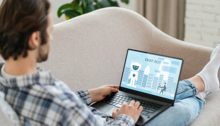 Guy reclining on couch, using laptop with chat bot