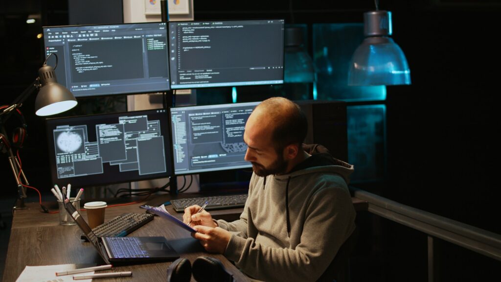 IT system engineer comparing data files on clipboard papers