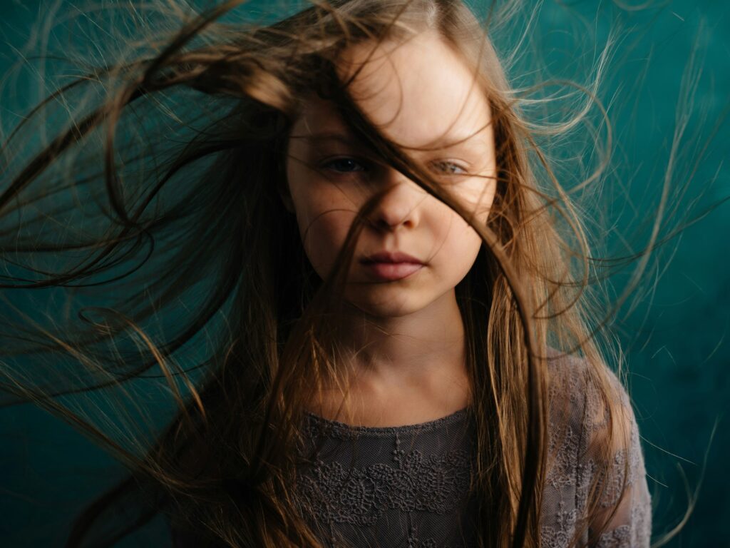 little girl loose hair Green background dissatisfaction emotions