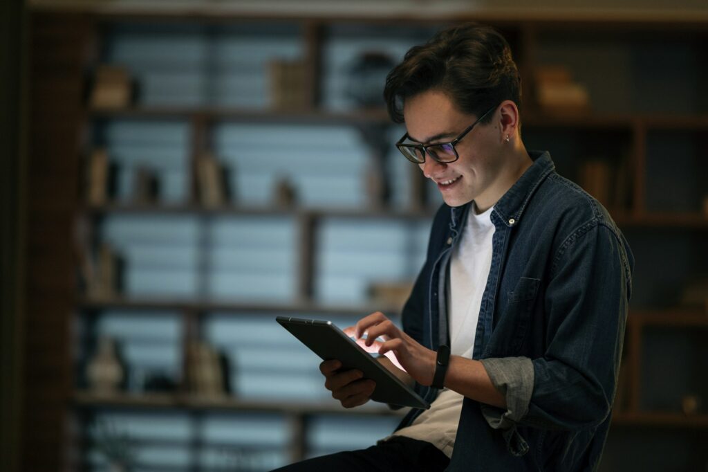 Smiling young man professional holding using digital tablet at office