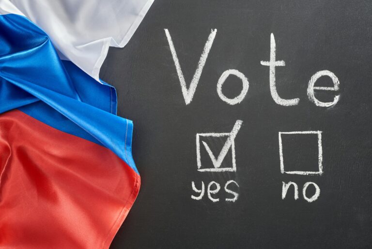 top view of vote lettering and check mark near yes word on black chalkboard near European flag