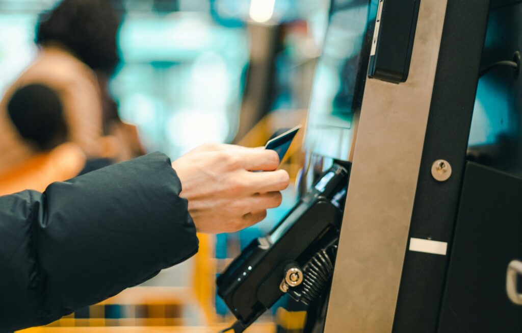 A young guy pays for purchases at the checkout in a store.