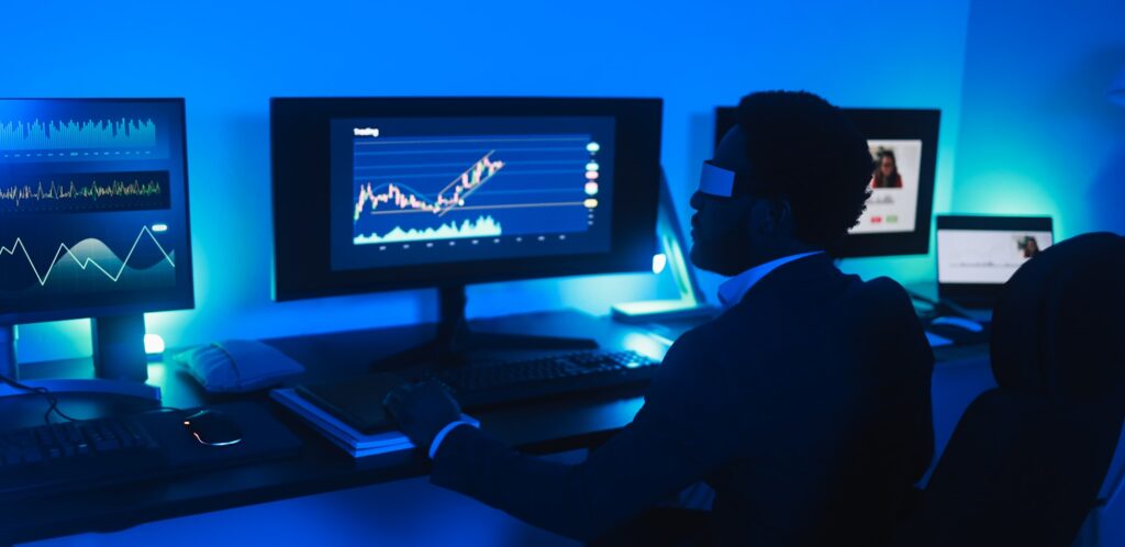 African man trader working inside office at night time wearing virtual reality headset