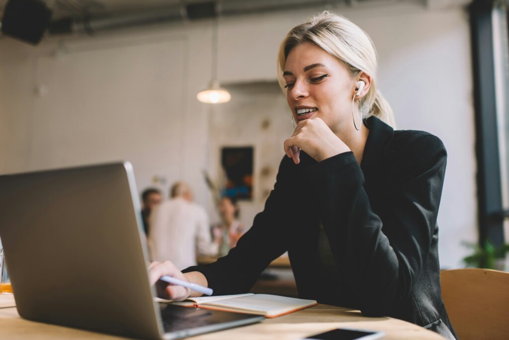 Caucasian manager in electronic earbuds watching professional webinar video on modern laptop compute