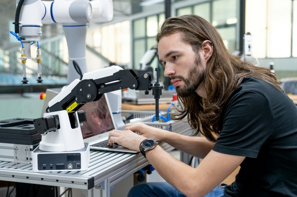 Engineer inspecting automatic AI robot arm and machines in factory. Engineer inspecting automatic AI