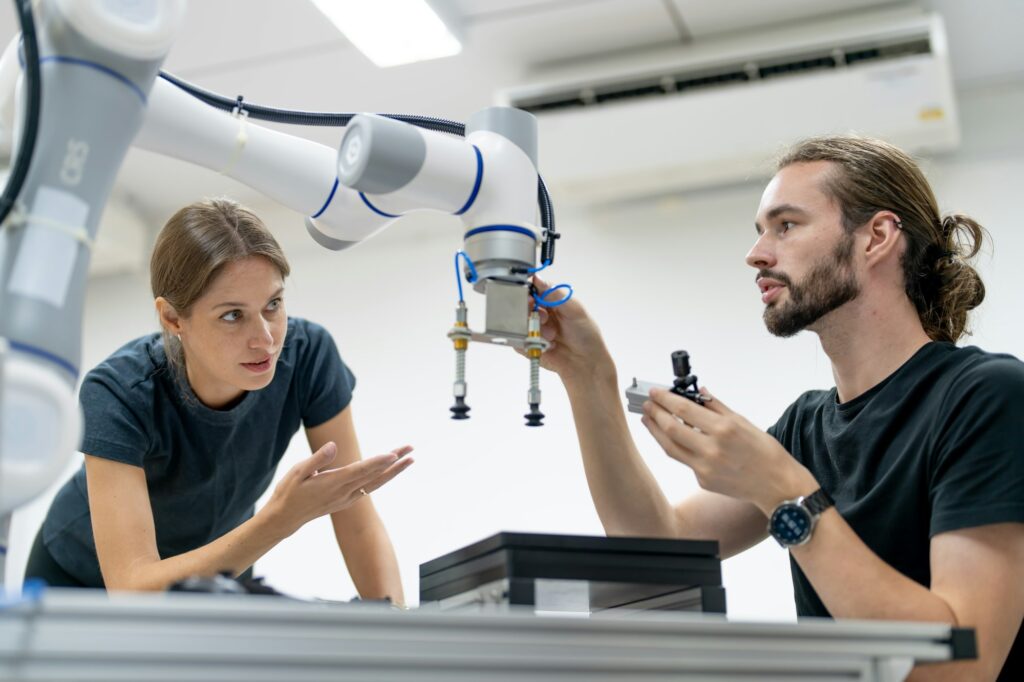 Engineer inspecting automatic AI robot arm and machines in factory. Engineer inspecting automatic AI