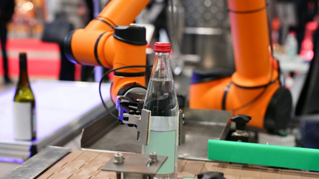 Futuristic automated robotic Hand Picks up a water bottle. Mineral-table water bottling shops.