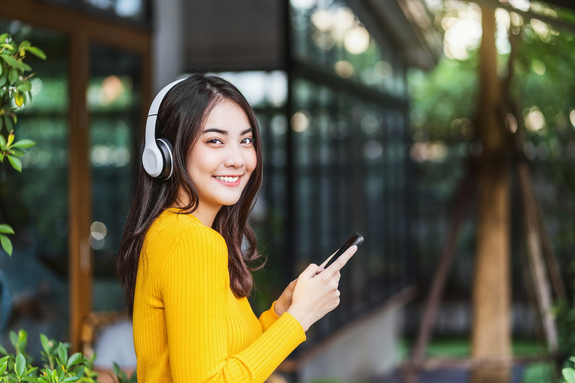 Happiness Asian smiling young woman wearing technology wireless headphones